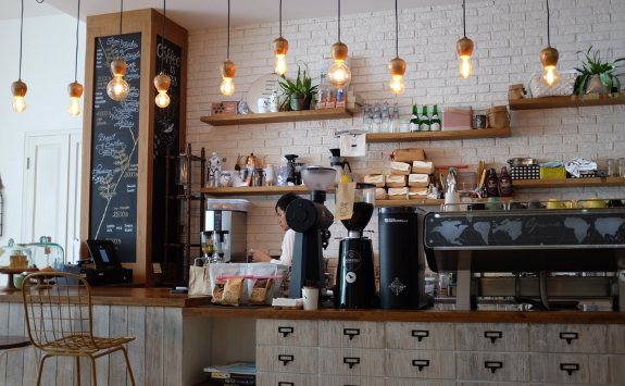 A person works in a quiet, small coffee shop